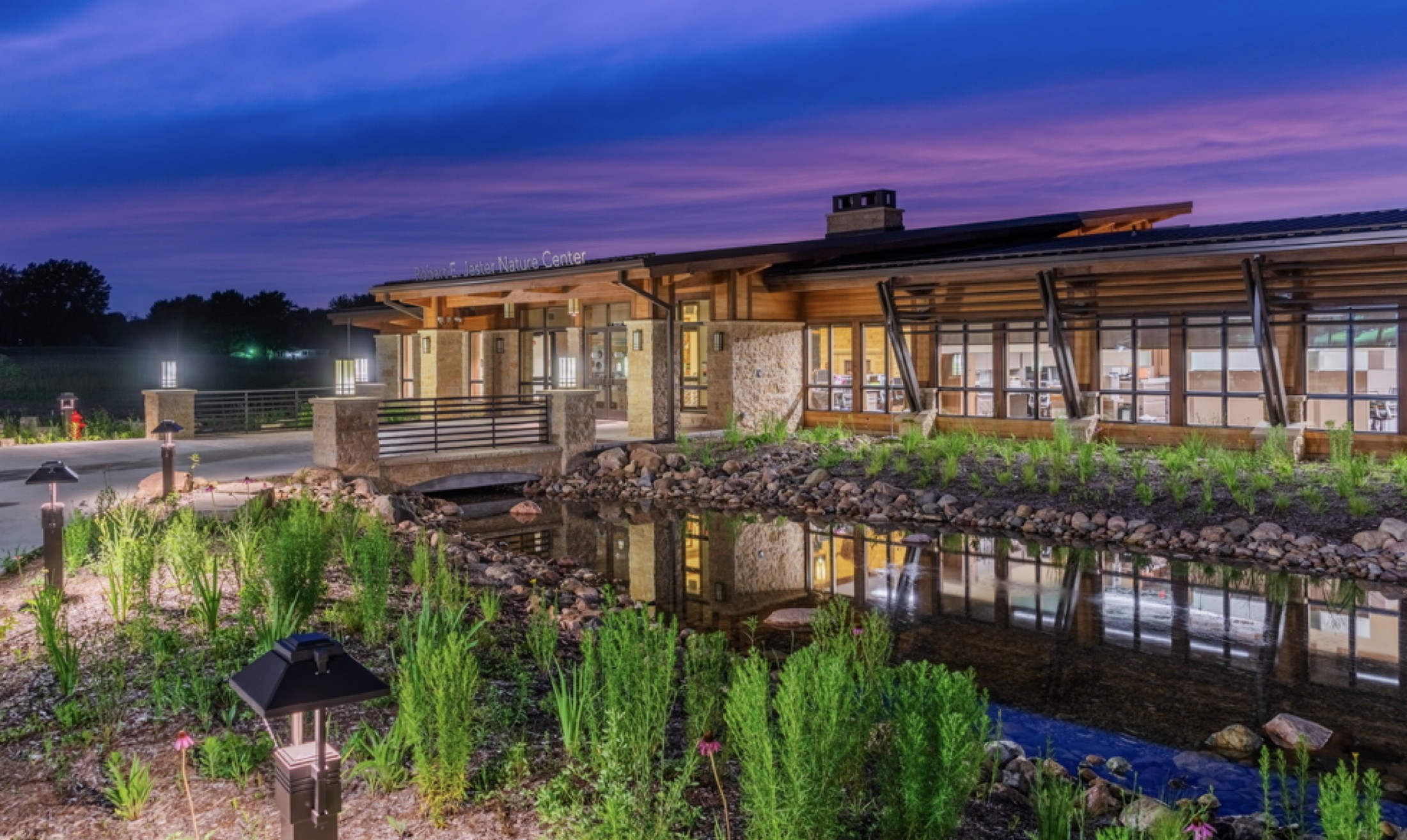 Jester Park Nature Center front elevation reflected in water at dusk